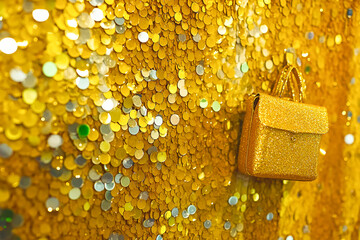 Poster - Golden glittery purse adorned against a sparkling background of golden sequins creating a luxurious aesthetic