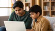 © Jo - Two Indian Boys Discussing Homework Over Laptop in Study Lounge
