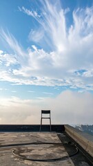Poster - Single Chair on Rooftop Edge Inviting Contemplation Under Clouds