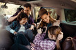 © Davor - Happy family sitting in car taking pictures during road trip