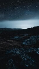 Wall Mural - a dark sky with a few stars and a mountain range in the background. the sky is filled with a sense o