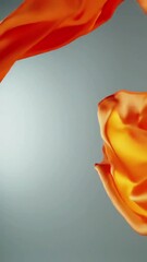 Poster - Flowing Orange Fabric: Abstract Motion and Smooth Texture on Grey Background
