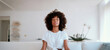© Postmodern Studio - Tranquil meditation at home with a young woman in a peaceful living room setting