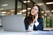 © maeching - Asian businesswoman working on financial market research using laptop and digital tablet, stressed about digital investment in office.