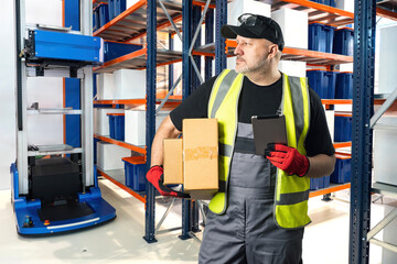 Poster - man in warehouse. automated warehouse equipment behind worker. man with electronic tablet in storage