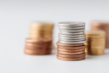 Poster - stacks of various currency coins neatly arranged on plain white surface with ample copy space setup emphasizes minimalistic
