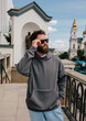 © San4ezz007 - Bearded hipster in dark grey hoodie and sunglasses – urban apparel mockup