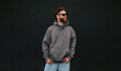 © San4ezz007 - Bearded hipster in dark grey hoodie and sunglasses – urban apparel mockup