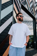 © San4ezz007 - White T-shirt on a bearded hipster in sunglasses — urban mockup for brands