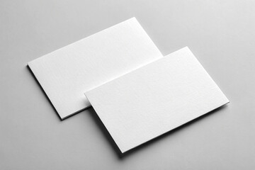 Two blank, white, rectangular pieces of paper, likely business cards