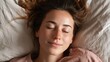 © Ірина Пальцева - Relaxed woman with closed eyes resting in bed. Enjoying a peaceful moment of tranquility, sleep, or rest on soft bedding in her home.