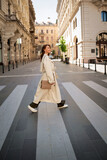 Full length of an attractive brunette haired woman walking through the pedestrian crossing