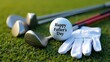© MariPon - Golf Ball with Happy Father's Day Inscription among Clubs and Glove on Green Grass