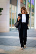 © sepy - Businesswoman heading to the office and using mobile phone