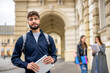 © Mediteraneo - Smiling Student Holding Tablet with Classmates in the Background..