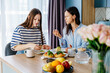 © Iryna - Mother enjoying healthy toast while teenage daughter eats breakfast