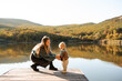© morrowlight - Young woman holding baby girl 1 year old wearing knitted sweaters over nature landscape view. Motherhood. Autumn season.