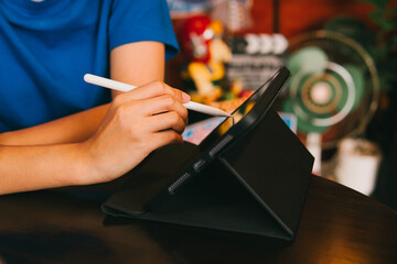 Poster - Person Using Digital Tablet with Stylus in Modern Workspace, Engaging with Technology and Creativity