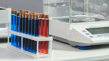 Poster - Row of blue and red test tubes lined up on white laboratory table. Medical chemical analysis concept background.