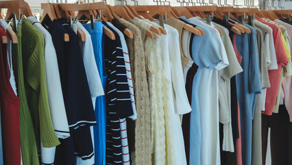 Poster - A rack of clothes with a variety of colors and styles. The clothes are hanging on wooden hangers