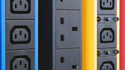 Poster - A row of electrical outlets in different colors. The blue and yellow outlets are next to each other