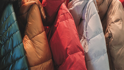 Poster - A row of jackets with different colors and patterns. The jackets are hanging on a rack