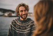 © Centric  - Young smiling bearded man wearing traditional scandinavian sweater talking to blurred woman in a fishing village by the sea