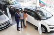© Prostock-studio - Buying Car. Auto Showroom Manager Consulting Young Black Spouses, Happy African American Couple Purchasing New Auto In Modern Dealership Center, Listening Vehicle Characteristics, Top View Shot