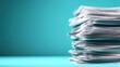 © Natchanok - Stack of White Paper Documents on Teal Background Studio Shot Close Up Overload Bureaucracy Administration Pile of Files