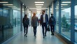 © Almas Ikhwan - Blurred view of business colleagues walking in a brightly lit office hallway at daytime.