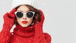 © DSimage - Attractive woman wearing a red sweater, white hat, and sunglasses against a neutral background.