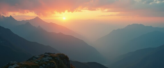 Poster - Scenic mountain panorama at sunset with golden sunlight illuminating hazy peaks and a rocky foreground