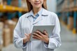 © Dzikrul Husnani - Woman Using Tablet in Storage Facility for Inventory Management