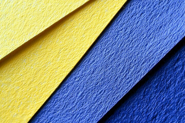 Poster - Abstract composition of textured yellow and blue papers forming diagonal lines with close-up focus on surface details and color contrast