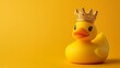 © Laman - Photograph of yellow rubber duck with a golden crown sits on a solid yellow background.