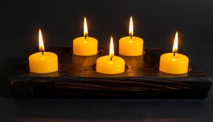 Wall Mural - burning candles glow with yellow light and flame in the darkness of night, a decoration for holiday 
