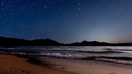 Wall Mural - sunrise over the sea with gentle waves and fading stars in a peaceful, dreamy atmosphere