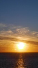 Sticker - Vertical Video Timelapse of Sun Setting Over Ocean with Waves Rolling In with Reflection on Sea as It Disappears Beyond Horizon. Filmed on Woolacombe Bay in North Devon, UK.