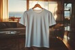 © kang - Blank white t-shirt hanging on wooden hanger in cozy room.