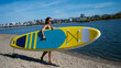© Михаил Решетников - Caucasian woman walks along the beach and carries a sup board on the river in the city. Summer sport.