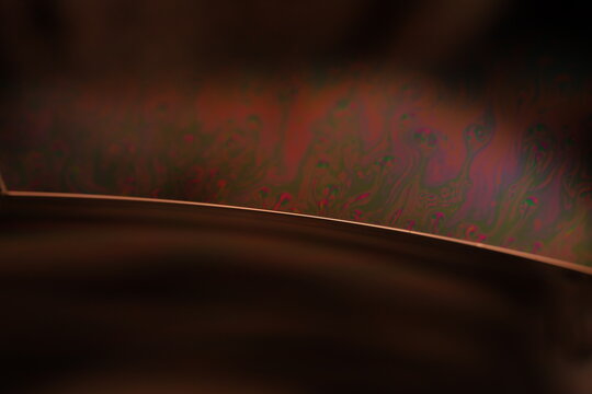 Brown liquid surface, green Reflections of liquid in macro,, bubbles in macro, connection of bubbles in macro, cell from liquid, dark background, glossy surface