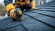 © Alokya - Close-up view of a roofer installing asphalt shingles.