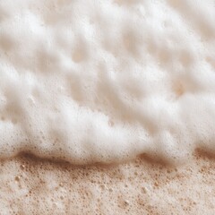 Poster - Close-up of Sea Foam Washing Ashore on a Sandy Beach; High Angle View of Ocean Waves and Sand Texture