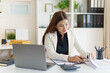 © matinee - Professional busineswoman analyzing charts and budgeting in modern office.