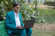 © Pix4Ads - Stylish and handsome Indian senior or matured business man working laptop in park. while sitting on the bench at the outdoor garden.. Adult business wearing corporate formal suit dealing business