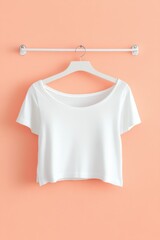 Poster - White Crop Top Hanging on Hanger Against Peach Wall Minimalist Style Fashion Apparel Mockup Clean Design