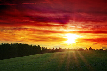Wall Mural - colorful sunset background with sun and big abstract clouds.