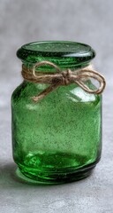 Poster - Green Glass Jar with Twine Bow on Gray Surface, Symbolizing Rustic Charm and Handmade Craftsmanship for Home Decor Projects : Generative AI