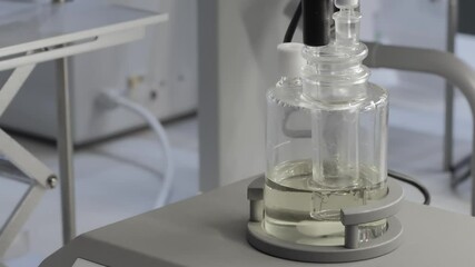 Poster - Glass ampoule with liquid being stirred on a device in a medical laboratory, medical analysis concept