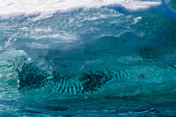 detail of a patch of antarctic sea ice, containing wonderous shapes and deep blue colours.